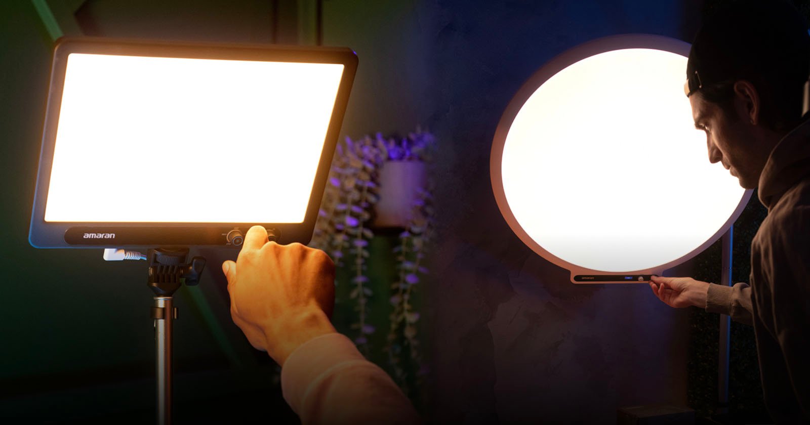A person adjusts the brightness on a rectangular LED panel light and a round LED panel light, both mounted on stands, in a dimly lit studio setting.