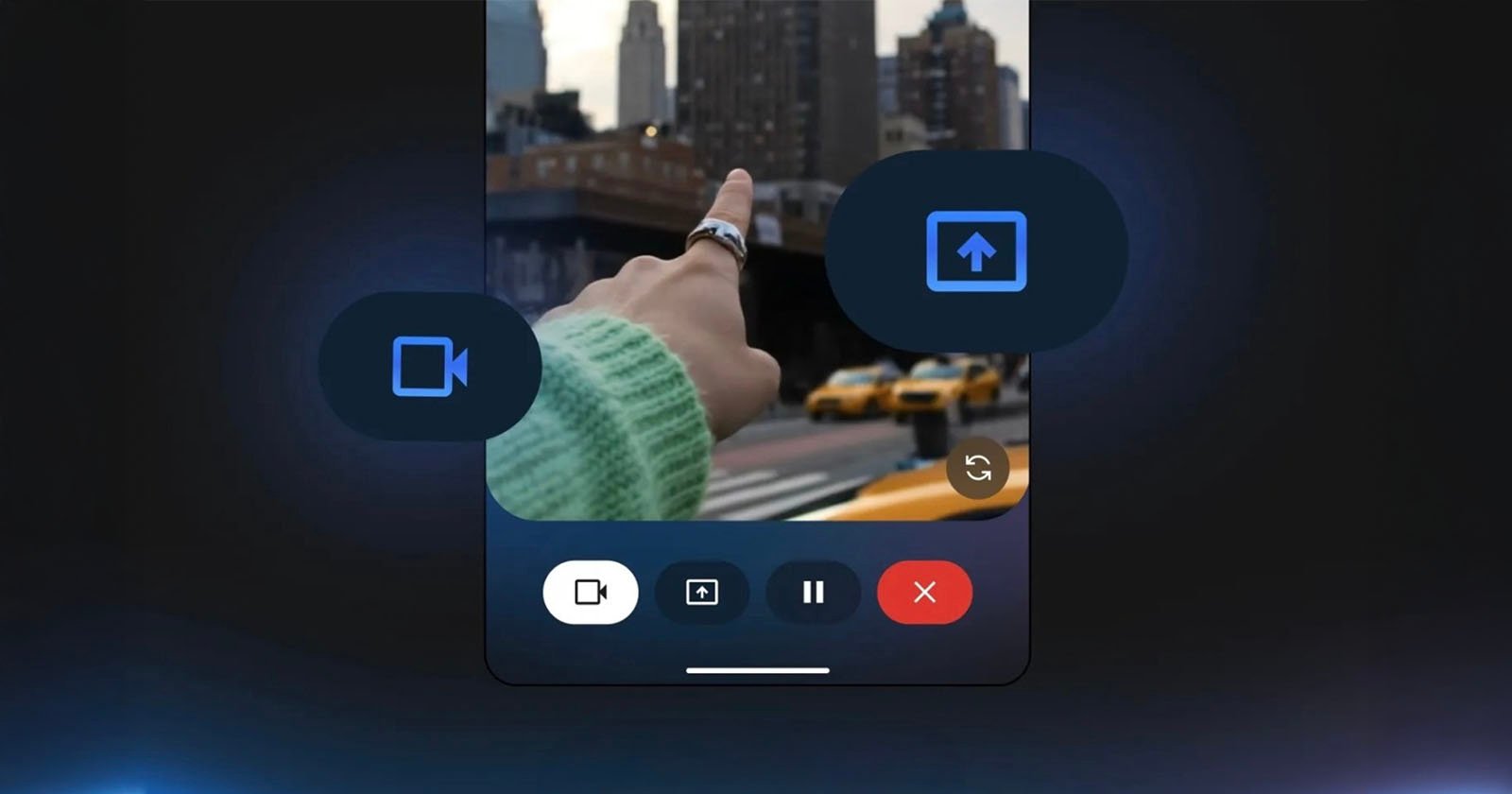 A person’s hand points toward city buildings as seen through a smartphone screen interface, with video and upload icons overlayed and yellow taxis visible in the background.